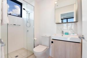 a bathroom with a toilet and a shower and a sink at Hope Street Apartments by CLLIX in Brisbane