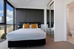 a bedroom with a large bed and a bathroom at Hope Street Apartments by CLLIX in Brisbane
