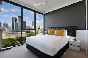 a bedroom with a large bed and a large window at Hope Street Apartments by CLLIX in Brisbane