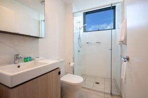 a bathroom with a toilet and a sink and a shower at Hope Street Apartments by CLLIX in Brisbane