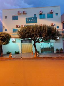 a tree in front of a building with a building at Araguaia Hotel in Bom Jesus