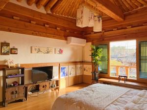 a bedroom with a bed and a flat screen tv at Siwoowadang in Gyeongju