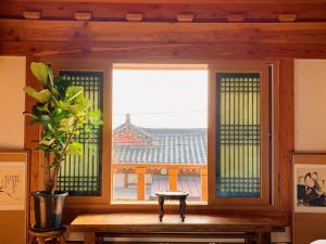 a window in a room with a table and a plant at Siwoowadang in Gyeongju