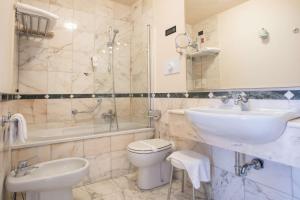 La salle de bains est pourvue d'un lavabo, de toilettes et d'une douche. dans l'établissement Hotel Plaza, à Pescara