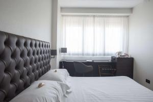 a bedroom with a large bed and a desk at Hotel Plaza in Pescara