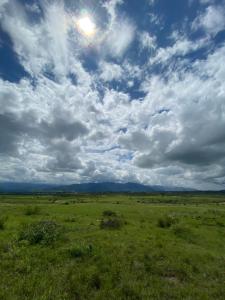un campo de hierba con un cielo nublado en Like Home en Salta