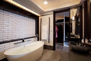 a bathroom with a large tub and a sink at Baba Beach Club Natai Luxury Pool Villa Hotel by Sri panwa - SHA Plus in Natai Beach