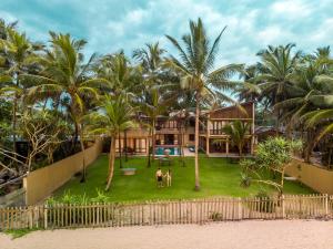 Villa 700 by Amaya في بينتوتا: منزل على الشاطئ مع أشجار النخيل