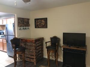 ein Wohnzimmer mit 2 Stühlen und einem Flachbild-TV in der Unterkunft Mon Chateau in Peoria