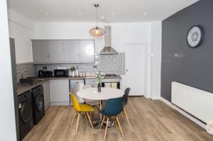 cocina y comedor con mesa y sillas en The Kensington House - Contemporary Accommodation in Nottingham, en Nottingham