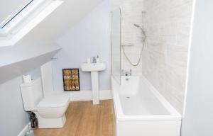 a bathroom with a toilet and a sink and a bath tub at The Kensington House - Contemporary Accommodation in Nottingham in Nottingham