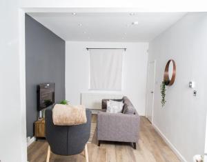 uma sala de estar com um sofá e uma cadeira em The Kensington House - Contemporary Accommodation in Nottingham em Nottingham