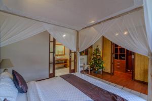 a bedroom with a bed with a christmas tree in it at Villa Essence in Seminyak