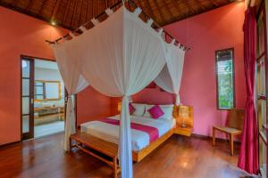a bedroom with a bed with a canopy at Villa Essence in Seminyak