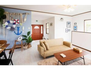 ein Wohnzimmer mit einem Sofa und einem Tisch in der Unterkunft Anjin Stay Awaji - Self Check-In Only in Akashi