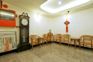 comedor con reloj, mesas y sillas en Nan Yeang Hotel Petaling Street, en Kuala Lumpur