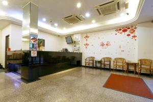 a waiting room with a table and chairs and a wall at Nan Yeang Hotel in Kuala Lumpur