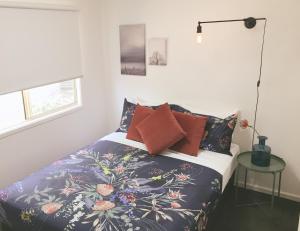 彭里斯Nepean Shores by Gateway Lifestyle Holiday Parks的一间卧室配有带色彩缤纷枕头的床