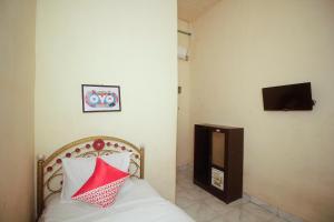 a bedroom with a bed with a red and white pillow at OYO 2555 Diva Residen Syariah in Jambi