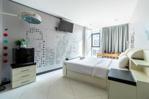 1 dormitorio con 1 cama y TV en la pared en The Secret Service Bed & Breakfast, en Bangkok