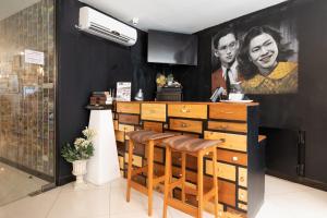 a restaurant with a bar with stools and a painting on the wall at The Secret Service Bed & Breakfast in Bangkok