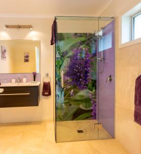 a bathroom with a shower with a glass door at Ribbonwood Country House in Cheviot