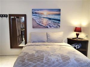 a bedroom with a bed and a picture on the wall at Coralito Malecon Luxury Studio in Isla Mujeres