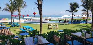 a restaurant with tables and chairs and the beach at Carinae Danang Hotel in Danang