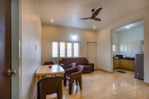 a living room with a table and chairs and a couch at Orchid Elite Service apartments in Mysore