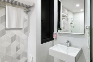 a white bathroom with a sink and a mirror at Hotel Z zpaze in Bangkok +174 photos