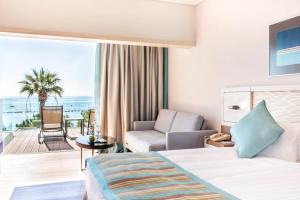 a hotel room with a bed and a living room at Crowne Plaza Limassol by IHG in Limassol