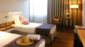 a hotel room with two beds and a hat on a table at Crowne Plaza Limassol by IHG in Limassol
