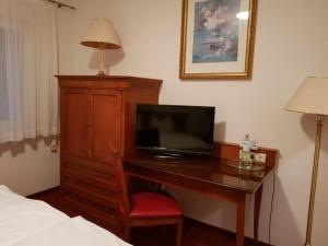 a bedroom with a desk with a television on it at Hotel zum Mückenberger Hof in Lauchhammer +7 photos