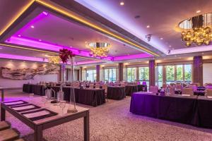 a ballroom with tables and chairs and purple lighting at Crowne Plaza Limassol by IHG in Limassol +37 photos