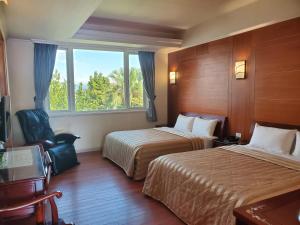 Cette chambre comprend 2 lits et une fenêtre. dans l'établissement Aegean Garden Motel, à Wujie