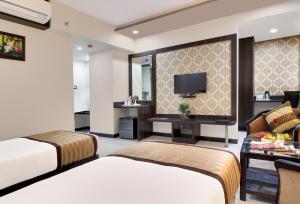 a hotel room with two beds and a tv at Rudransh Inn by Trulyy in Jodhpur