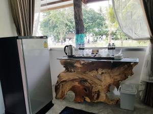 a kitchen with a table made out of a tree stump at In Touch Resort in Koh Tao