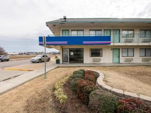a building with a car parked in front of it at Regency Inn Tulsa in Tulsa