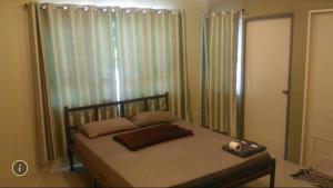 a bedroom with a bed and a window with curtains at Kim Casa in Nakhon Sawan +30 photos