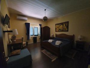 a bedroom with a bed and a couch and a window at Villa la Quercia Resort in San Salvatore Telesino