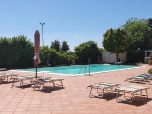ein Pool mit Picknicktischen und einem Sonnenschirm in der Unterkunft Villa la Quercia Resort in San Salvatore Telesino
