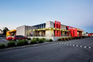 a building with a car parked in a parking lot at Nightcap at Excelsior Hotel in Melbourne