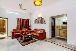 sala de estar con 2 sillas de cuero y mesa en NirmalVilla Cherry, en Hyderabad