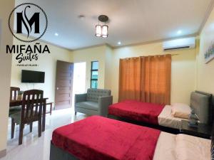 1 dormitorio con 2 camas, escritorio y silla en Mifaña Suites - Panglao Island, en Dauis