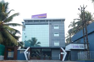 科泽科德Luxora Hotel and Spa的一座高楼，楼顶有标志