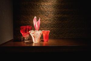 a vase with pink flowers in it on a table at Noku Kyoto in Kyoto