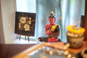 una figura sentada en una mesa junto a una pintura en PAVILION en Phnom Penh