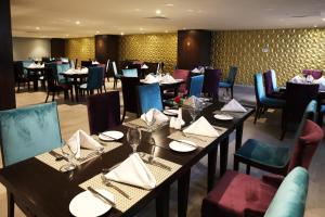 a dining room with tables and chairs in a restaurant at Avari Xpress, Islamabad in Rawalpindi