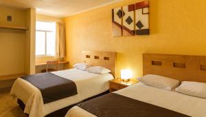 um quarto de hotel com duas camas e uma janela em Hotel Posada Santa Bertha em Texcoco de Mora
