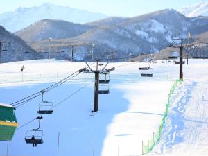 a ski slope with a ski lift in the snow at Hotel Sunny Valley in Otari